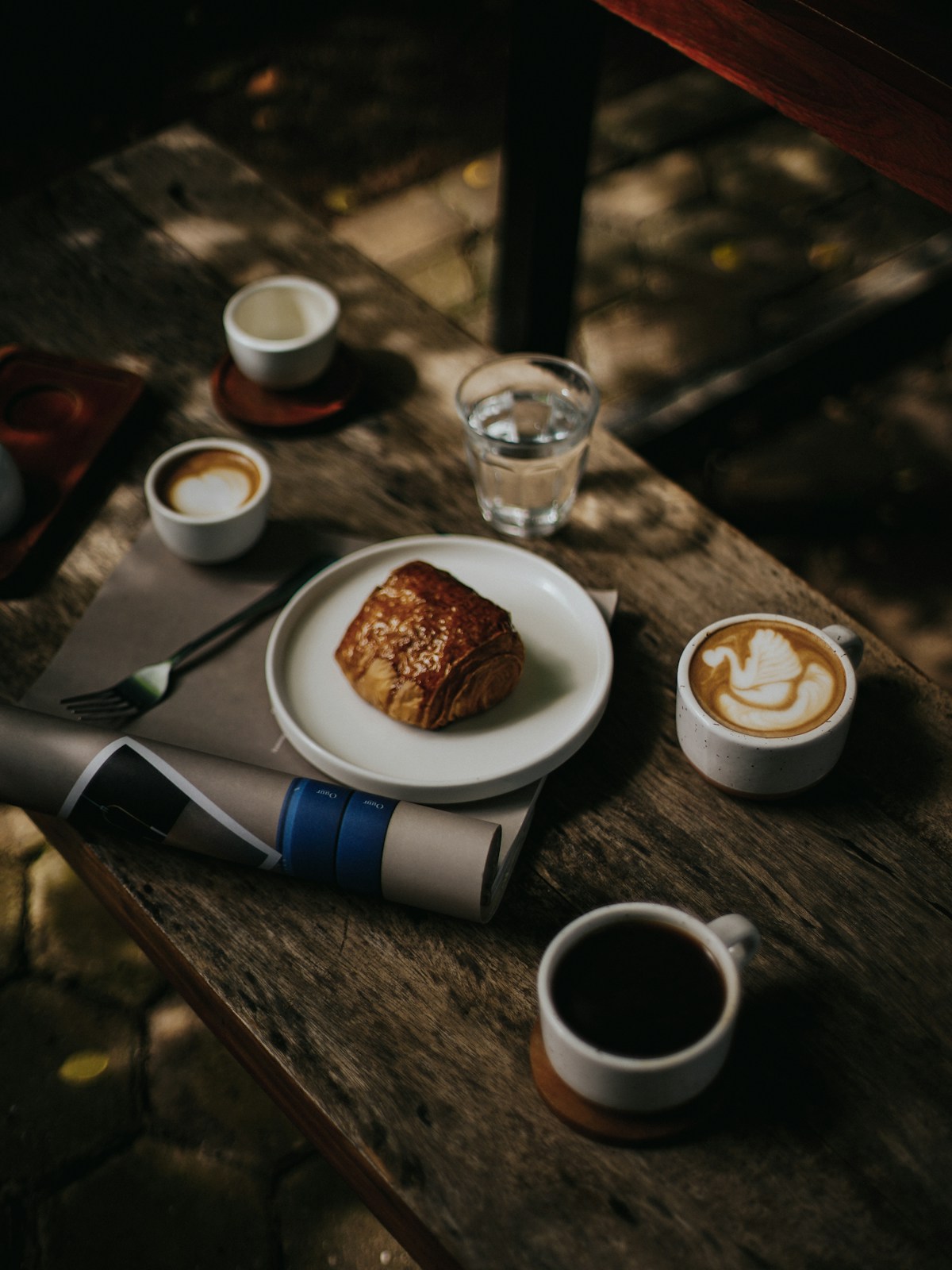 Pastry and coffees on a rustic wooden café table